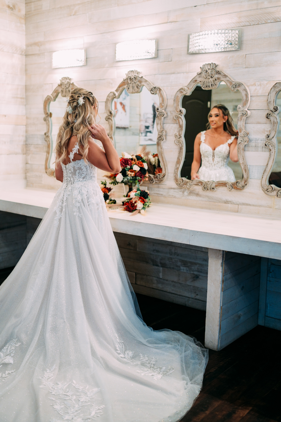 Bride in bridal suite looking at herself in the mirror at Ever After Farms Ranch